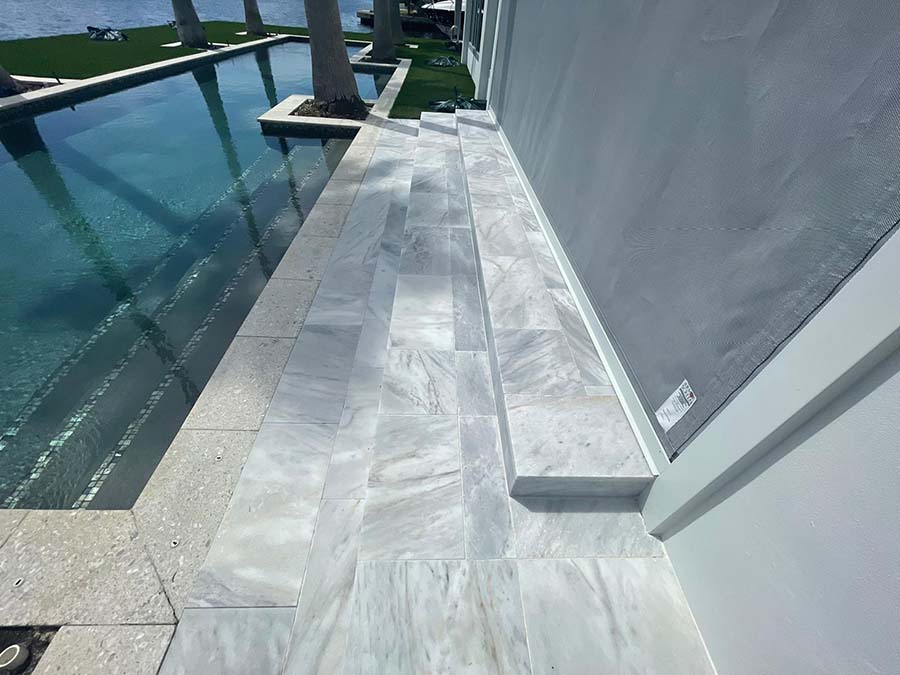StoneHardscapes Bianca neve tumbled marble pavers pool deck stairs 12x24